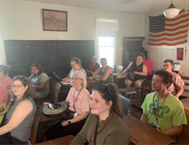 Image of teachers inside a one room schoolhouse during 2023 Road Trip.