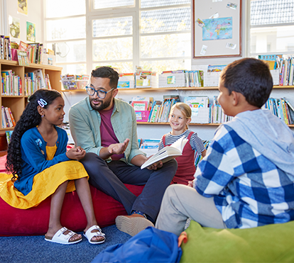 Teacher reading to class in a school library.
