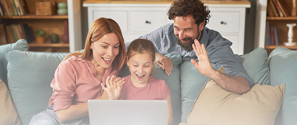 Parents and daughter looking at laptop.