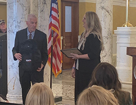 Kandy Flowers (right) of Wessington Springs, accepts a certificate and a teacher’s backpack from Sec. of Education Joe Graves