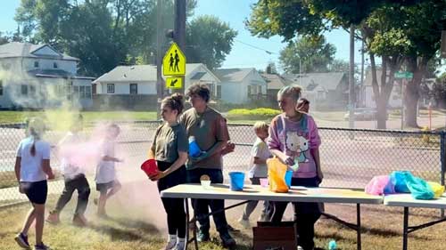 high school students volunteer with fun run event outside with elementary students